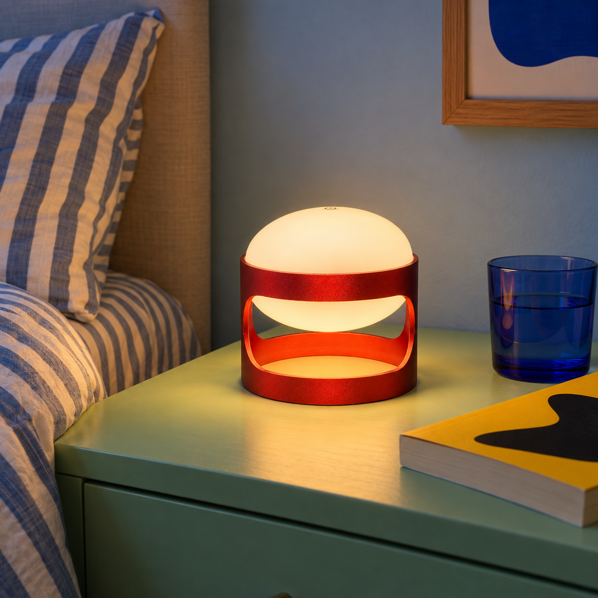 Lotus Mini cordless lamp in Deep Red, lit on a mint green nightstand